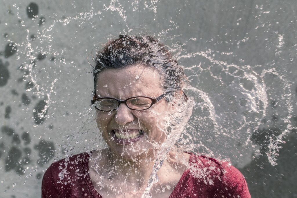 Frau wird mit Wasser angeschüttet